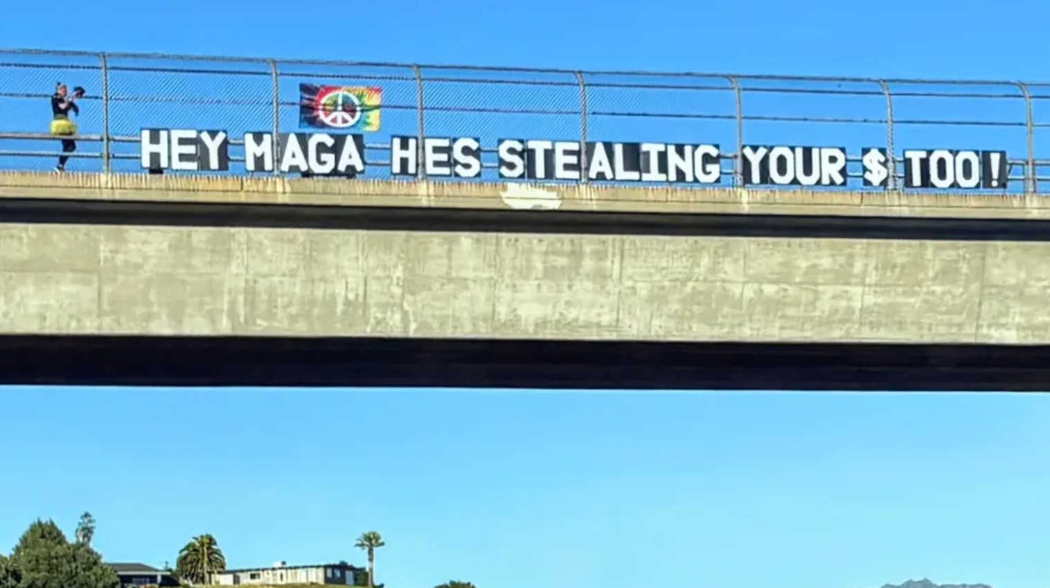 På et stort banner på en bro står det