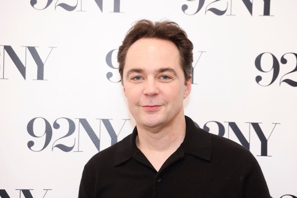 Person smiling at an event backdrop labeled "92NY," wearing a black shirt