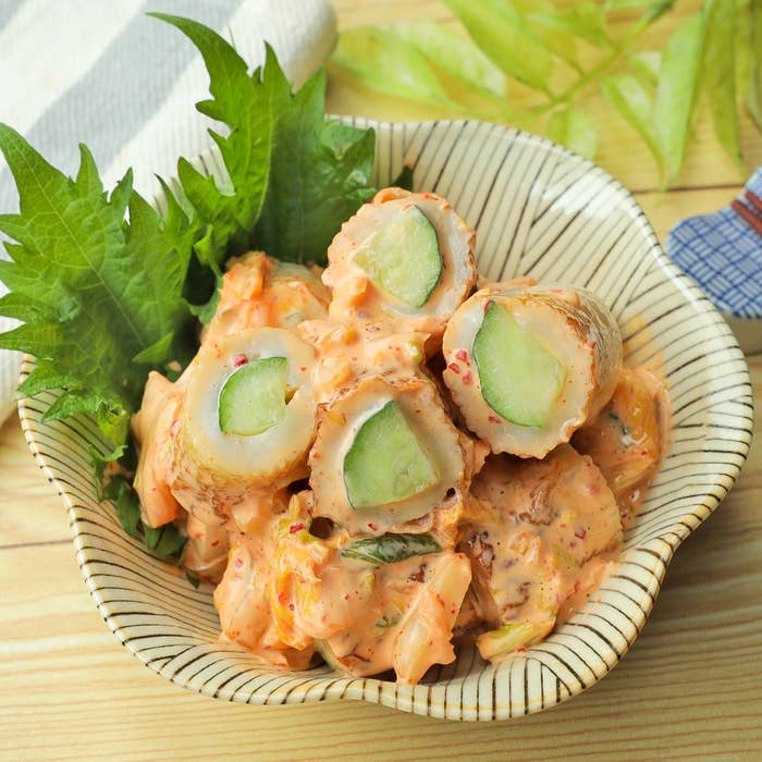 きゅうりを巻いたちくわに和風ドレッシングがかかった料理。器に盛り付けられ、シソの葉が添えられている。
