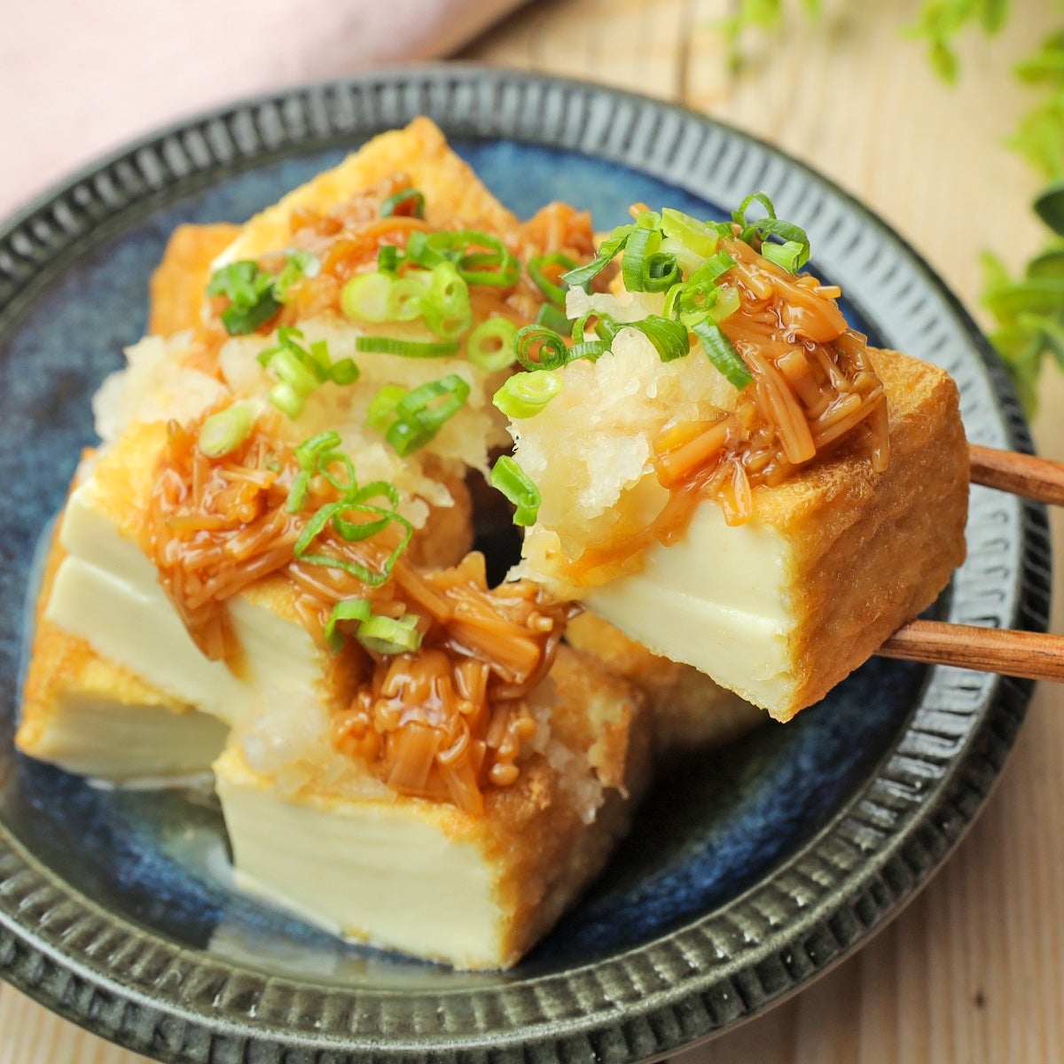 ネギとキノコのトッピングを施した豆腐の料理。食感豊かで和食らしい盛り付けです。