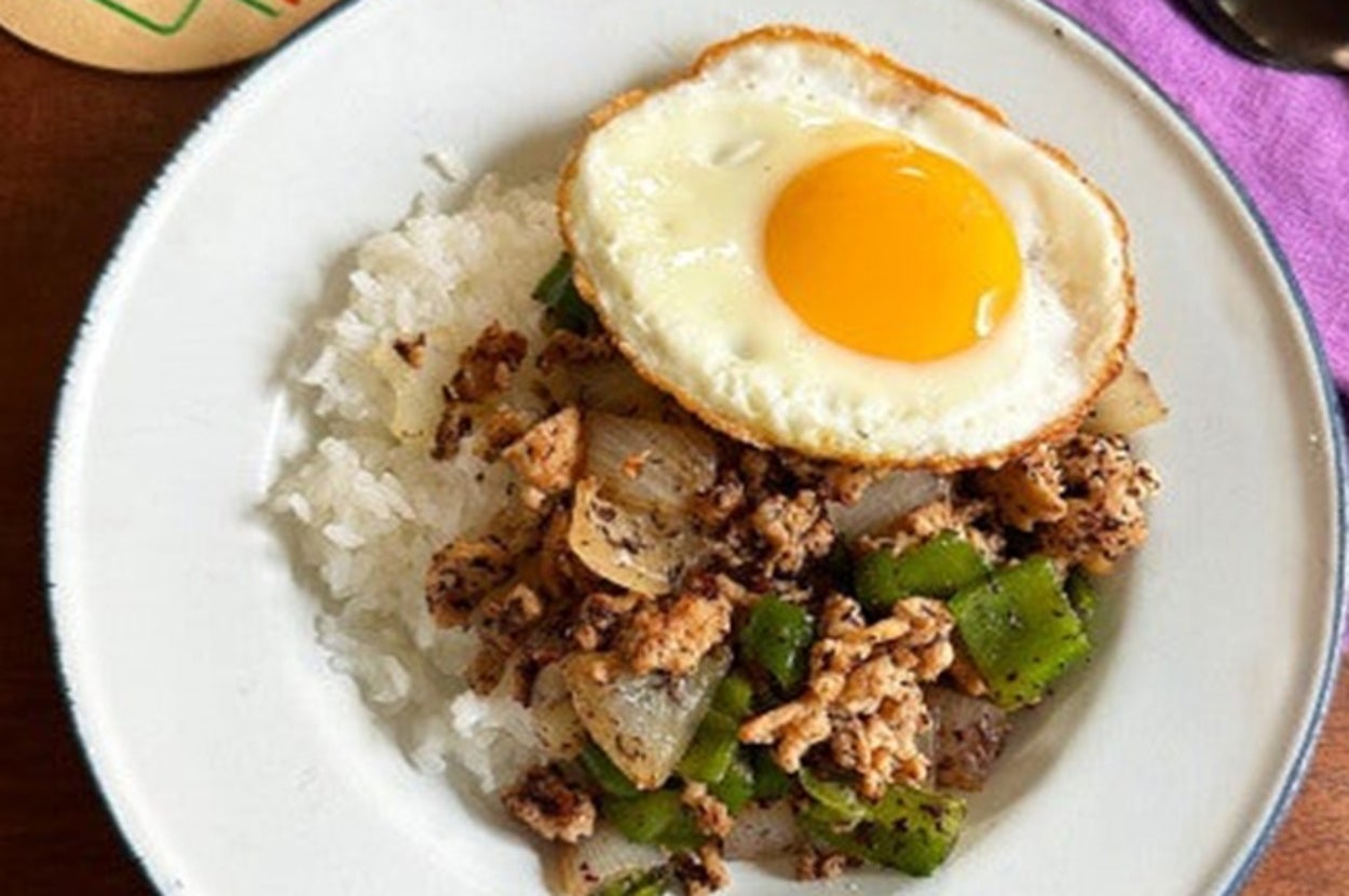 ご飯の上に玉ねぎとピーマン入りの炒めたひき肉と目玉焼きがのった料理。