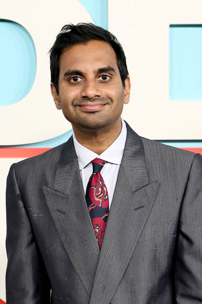Aziz Ansari in a tailored suit with a patterned tie at a formal event