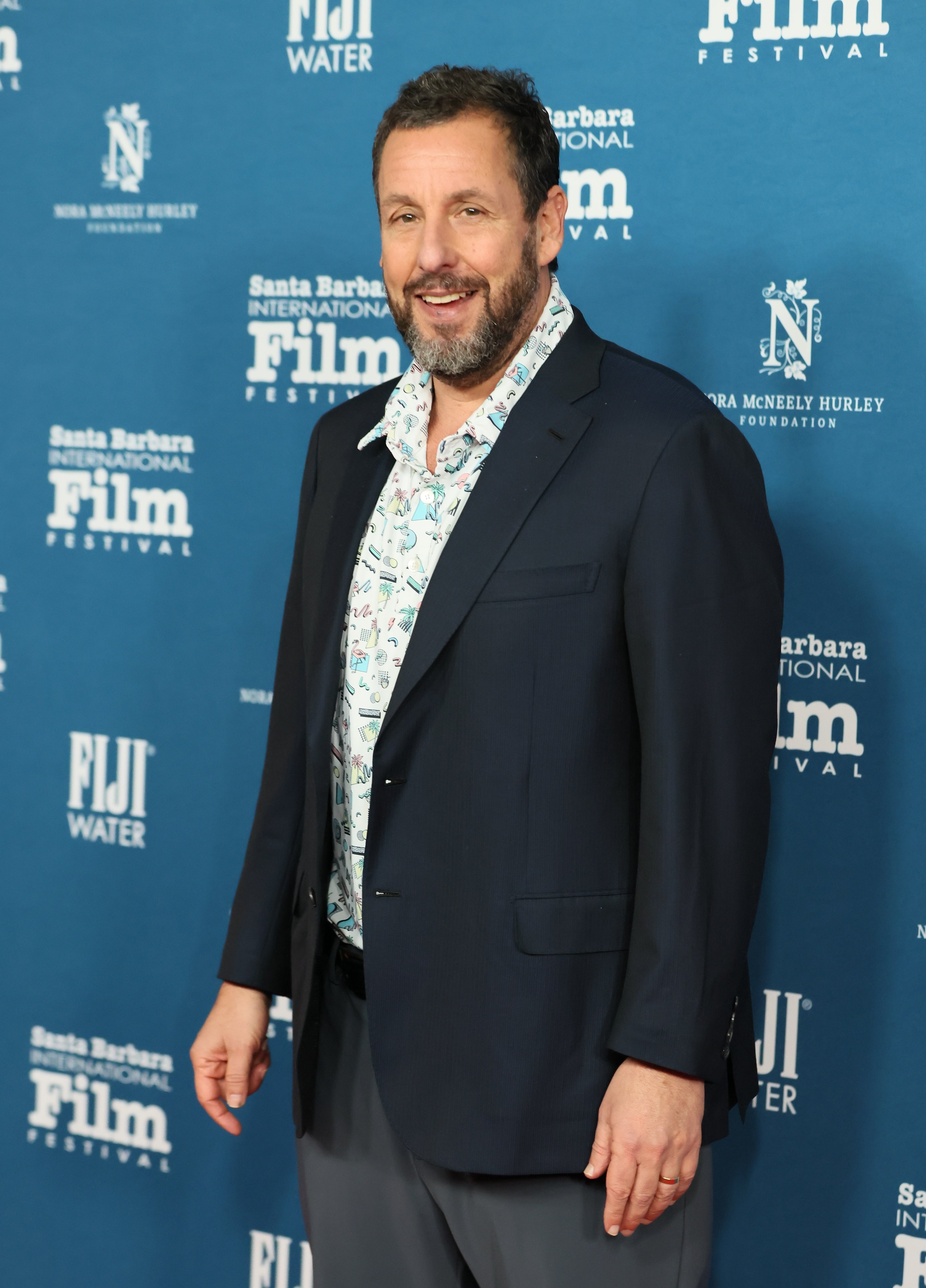 Adam Sandler connected a movie festival carpet, smiling astatine the camera