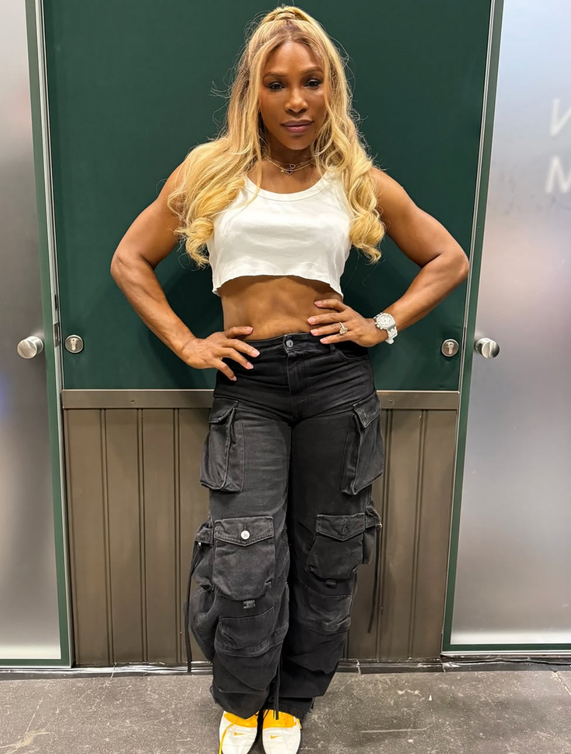 Serena wearing a white crop top and black cargo pants