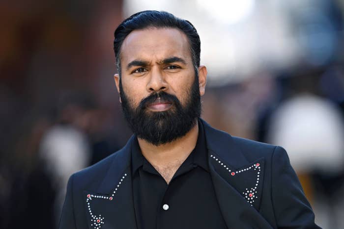 Person wearing a stylish studded jacket over a black shirt, looking directly at the camera with a neutral expression