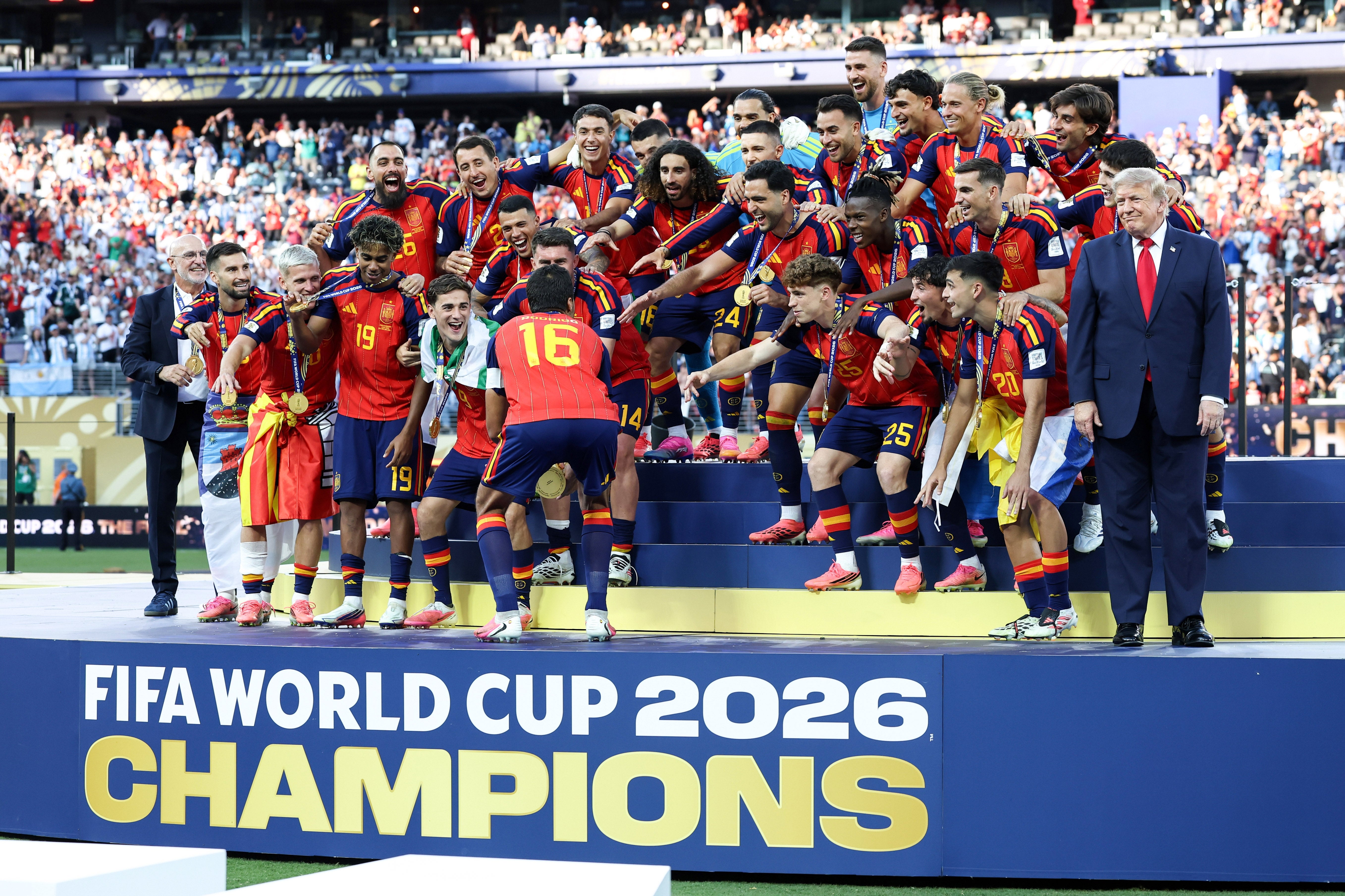 Soccer team celebrating on podium with "FIFA World Cup 2026 Champions" banner. Players wear matching sporty uniforms, posing with enthusiasm