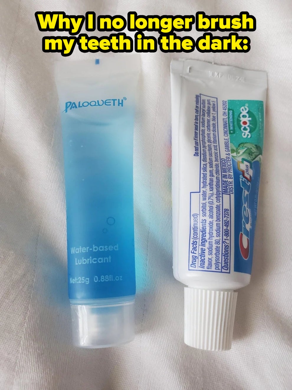 Tube of water-based lubricant next to a tube of toothpaste, both on a white surface