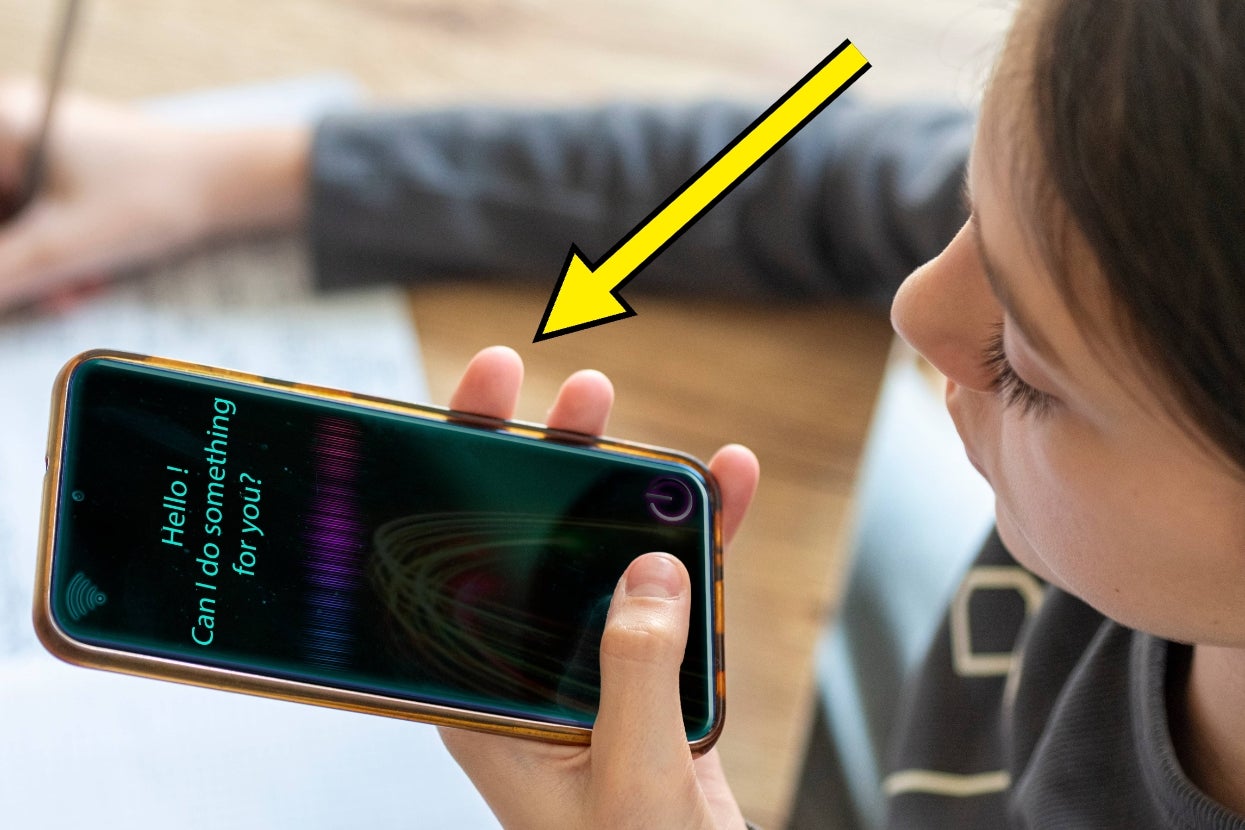 Person interacting with voice assistant on smartphone, indicated by an arrow. Screen reads, "Hello! Can I do something for you?"