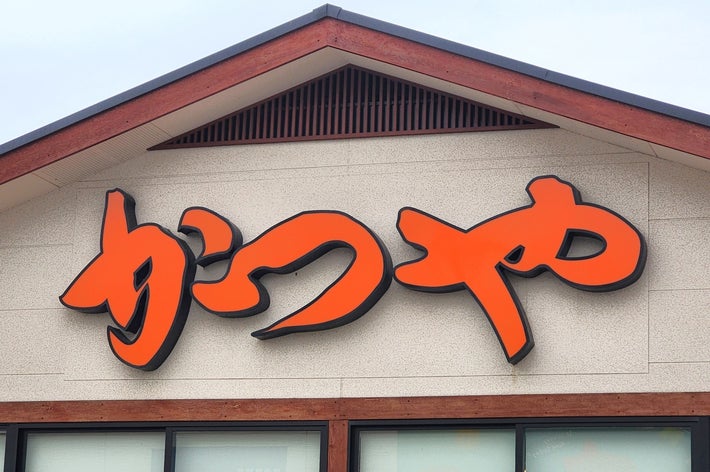 建物の上に「かつや」と書かれた看板がある