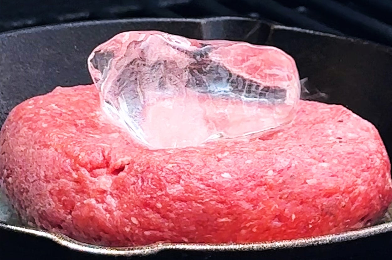 鉄板の上で調理中のハンバーグの中央に氷が置かれている。