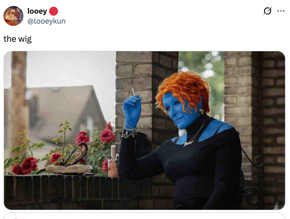 Person with bright orange hair and blue skin, wearing a black off-shoulder outfit, sitting on a porch, holding a cigarette