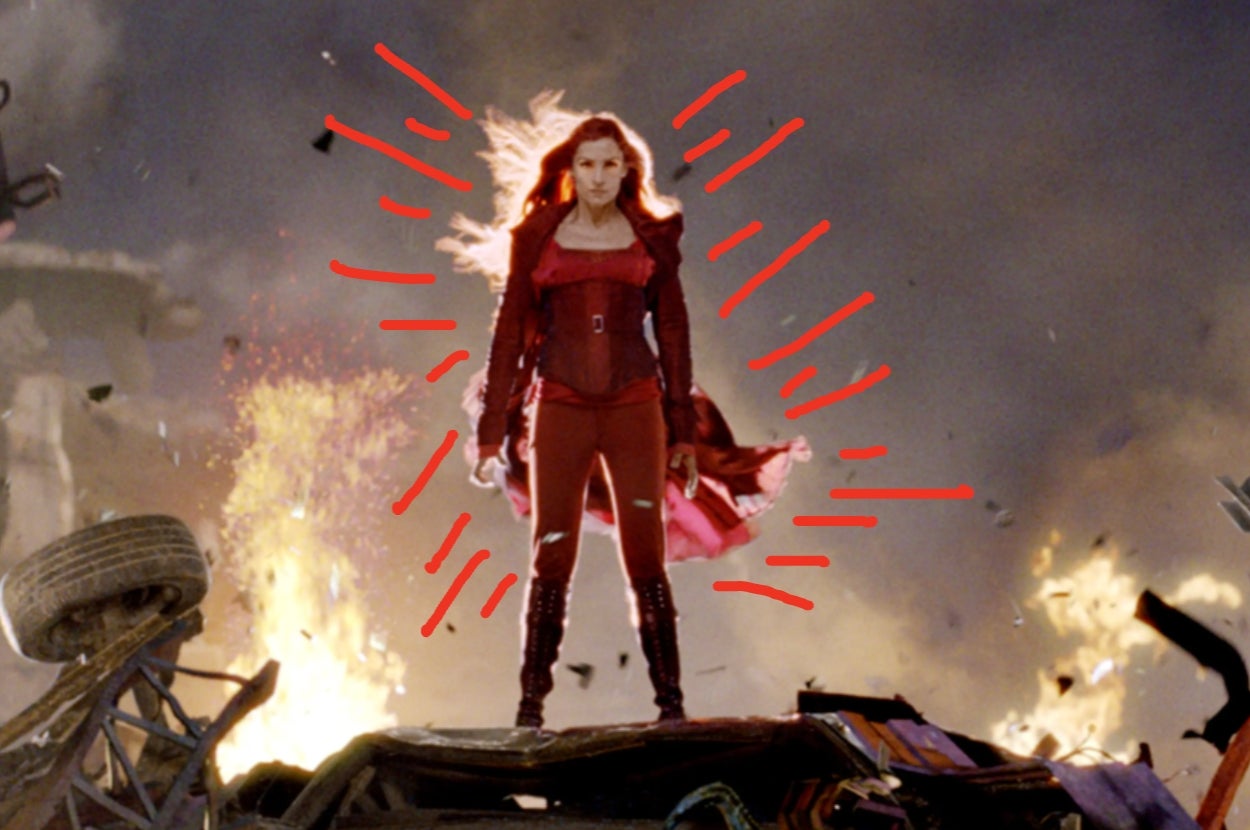 A superhero character stands on debris with a powerful pose, surrounded by explosions and wearing a fitted, dramatic costume
