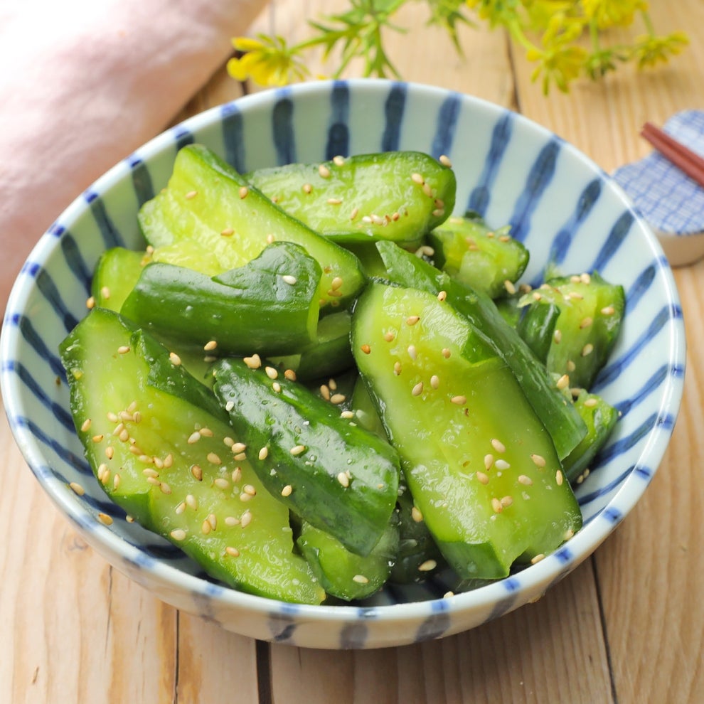 ボウルに盛られたゴマが振りかけられたキュウリの和え物。食卓に置かれている。