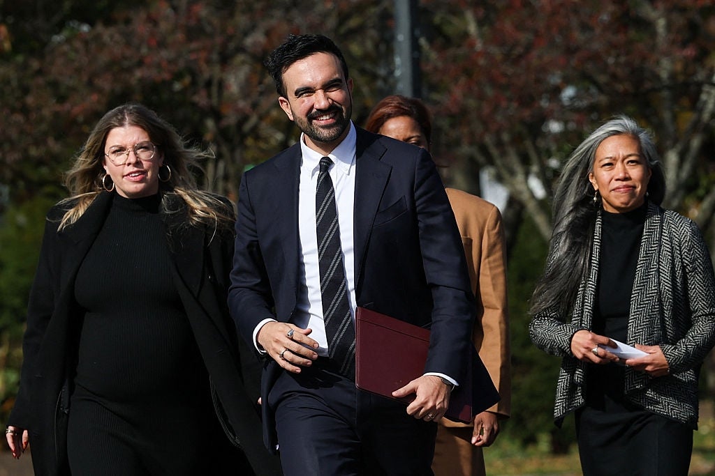 A radical  of radical   walking together, dressed successful  ceremonial  concern  attire, smiling outdoors