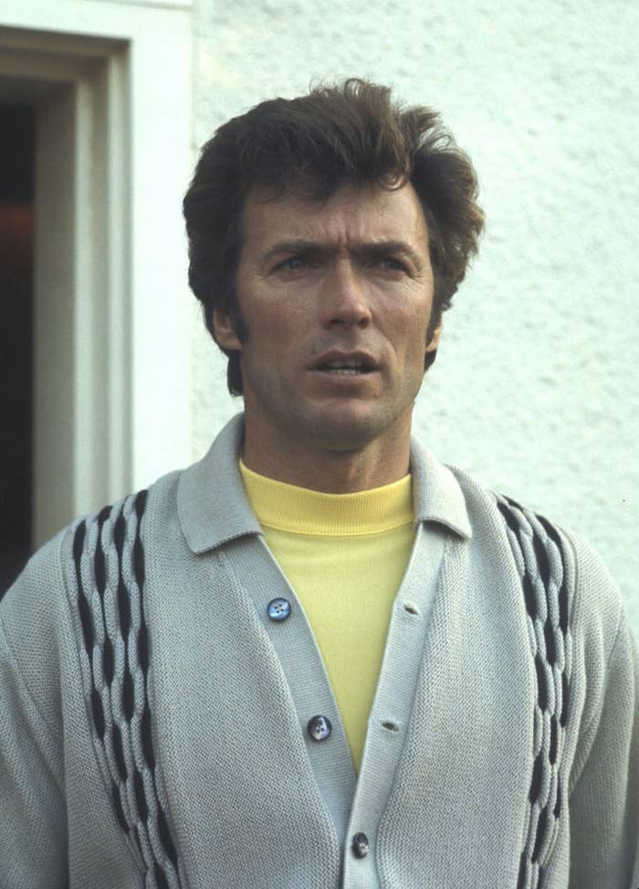 Person wearing a light cardigan with a patterned design over a yellow shirt, standing outside, looking ahead with a thoughtful expression