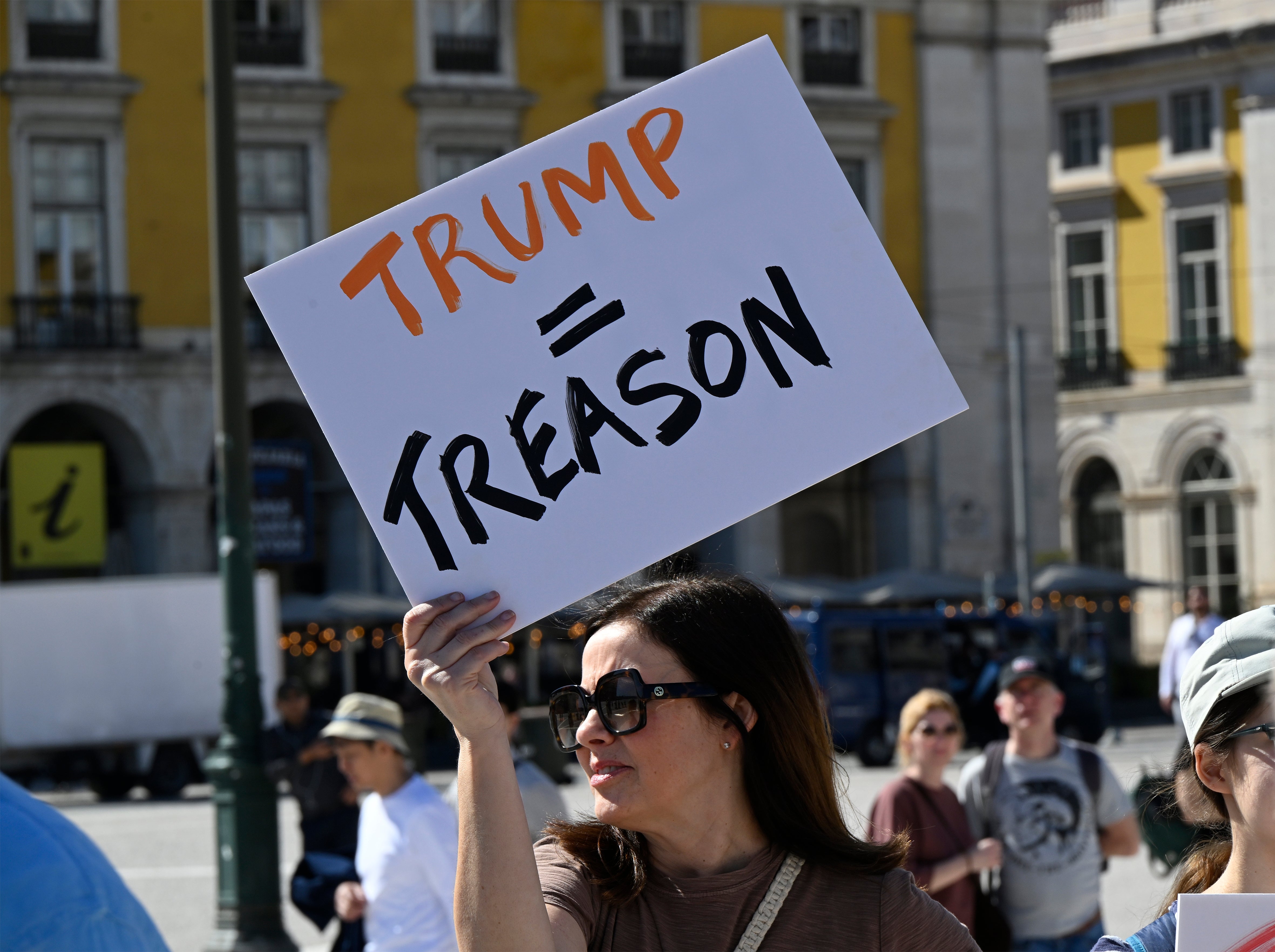 Person holds a protestation  motion   speechmaking  "Trump = Treason" during a nationalist   demonstration