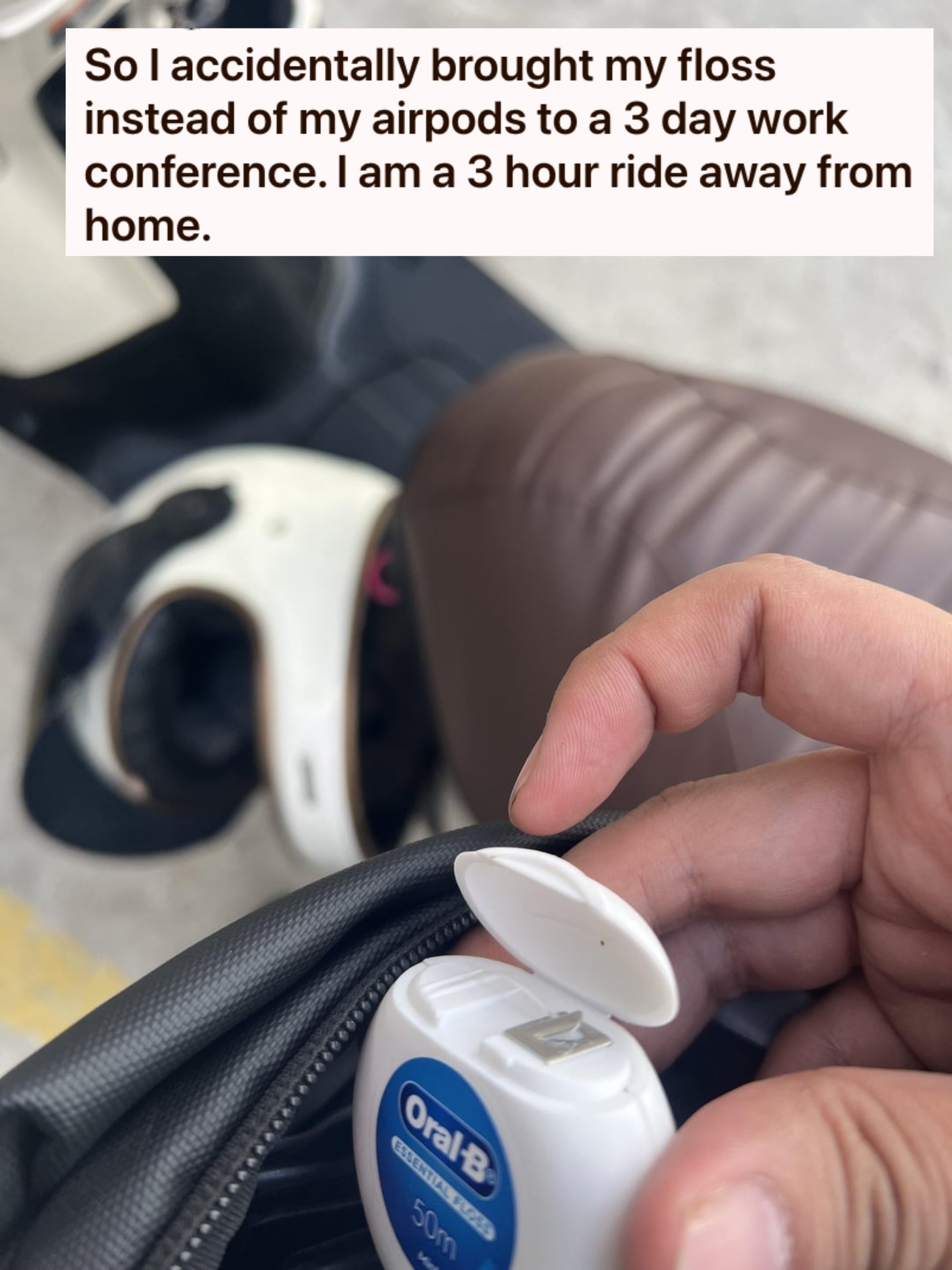 Hand holding Oral-B dental floss next to a scooter's seat and open storage compartment