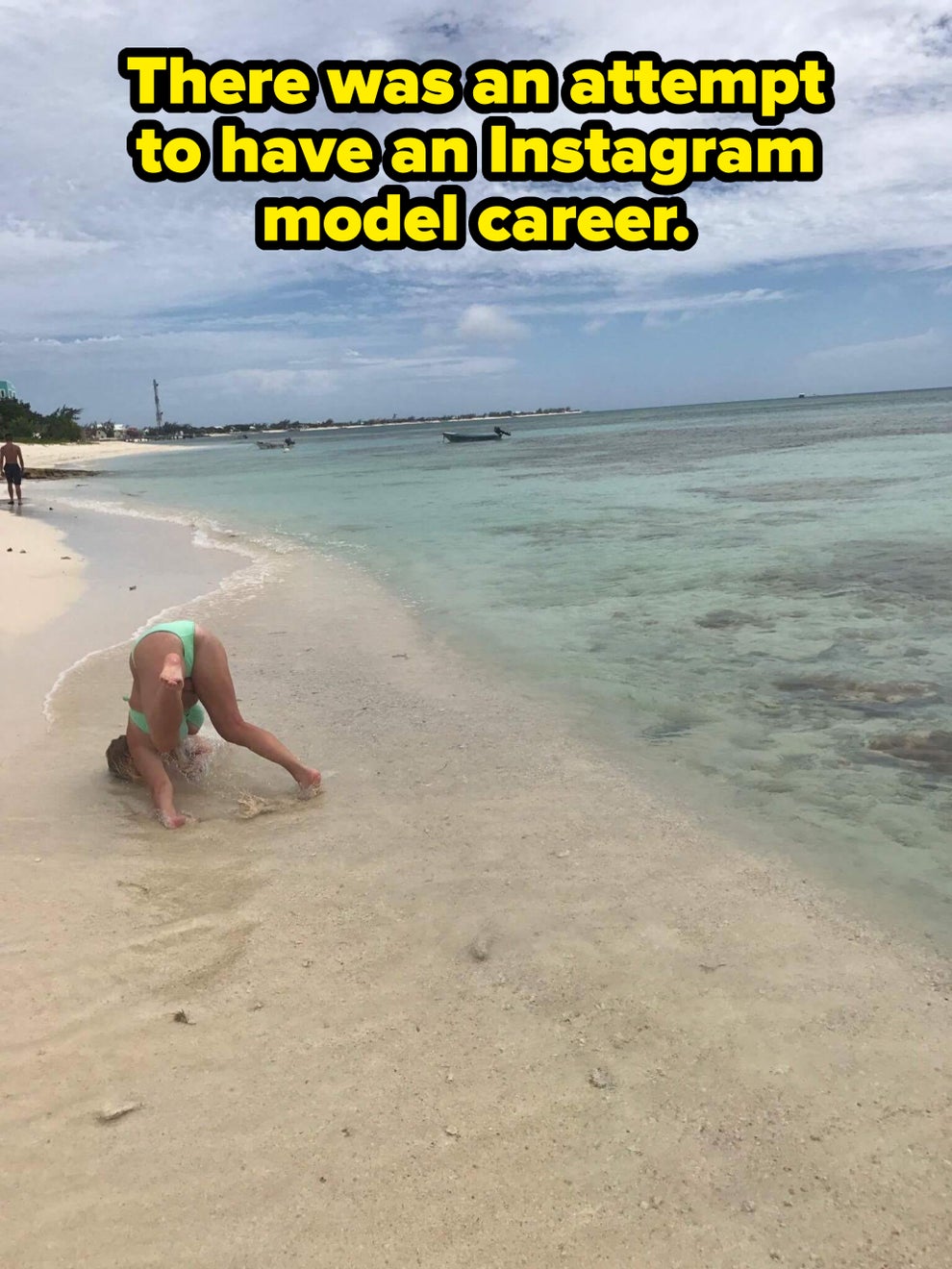 Person in swimsuit playing on sandy beach near calm sea under a cloudy sky