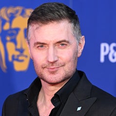Richard Armitage in a black suit on a blue background with a BAFTA logo