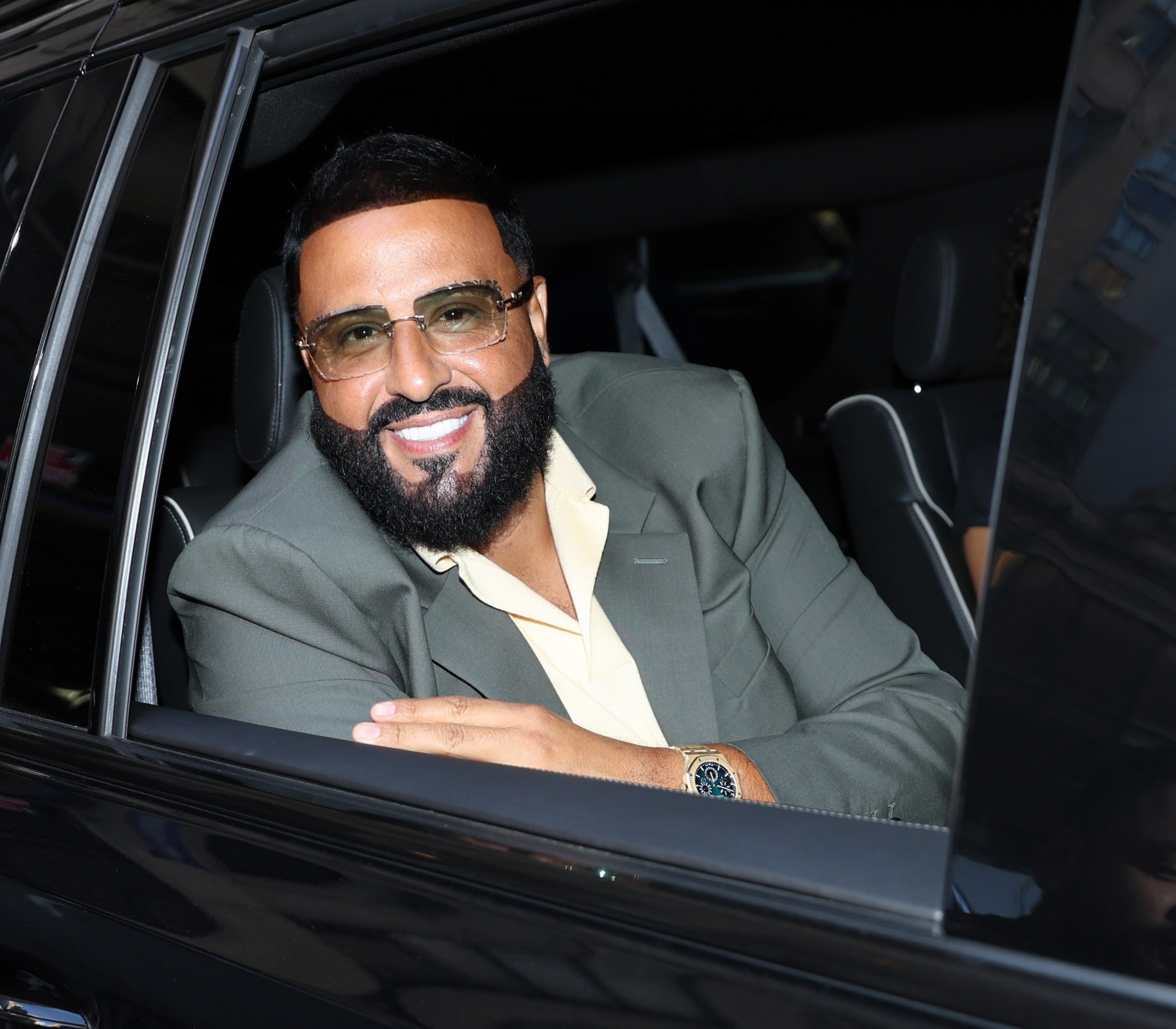 DJ Khalid smiling in a car with the window rolled down