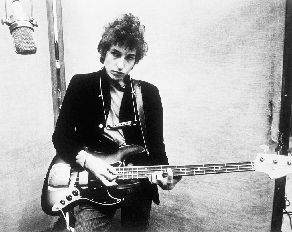 Bob Dylan holding a bass guitar in the 1960s