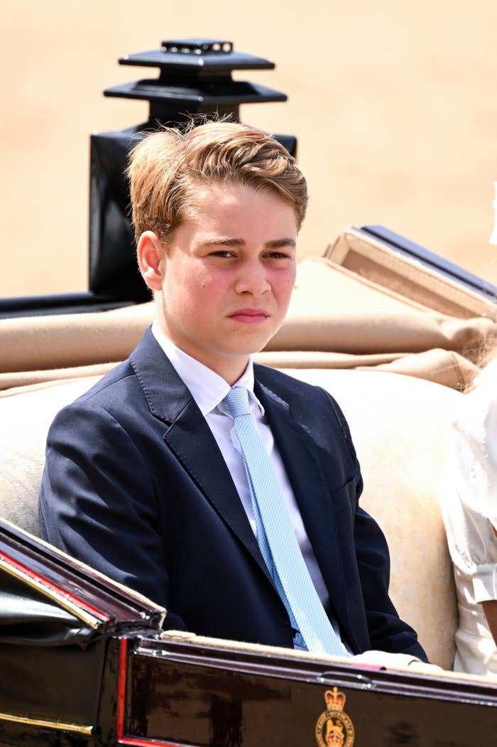 Young idiosyncratic   successful  a suit   seated outdoors during a ceremonial  event