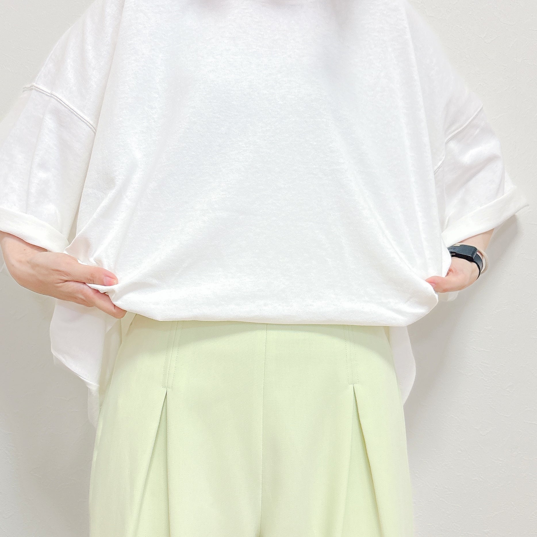 GU（ジーユー）の「スーパーオーバーサイズT ST」身長162cm女性でS/Mサイズを着用。裾を折ってワイドパンツに入れようとしている様子。