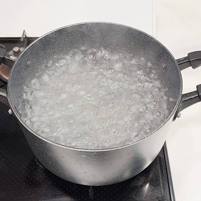 沸騰している鍋の様子。コンロの上に置かれ、泡が立って蒸気が上がっている。