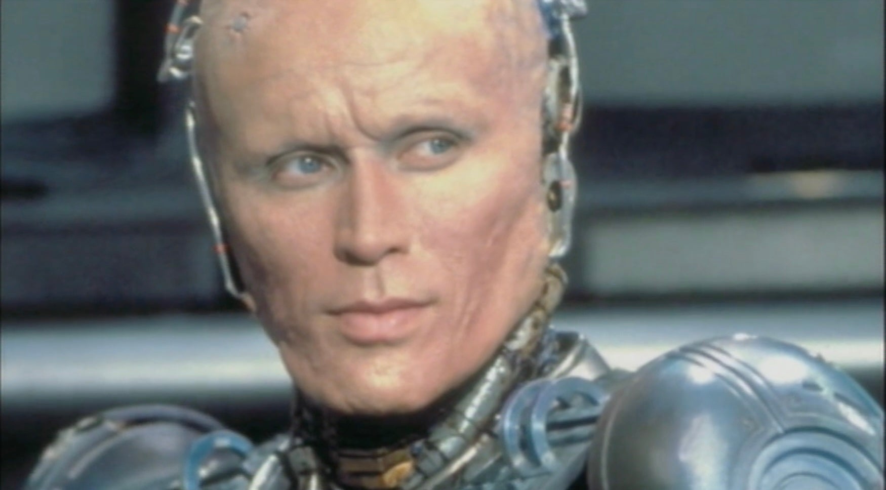 A futuristic cyborg with metal parts integrated into human features, looking to the side with a focused expression