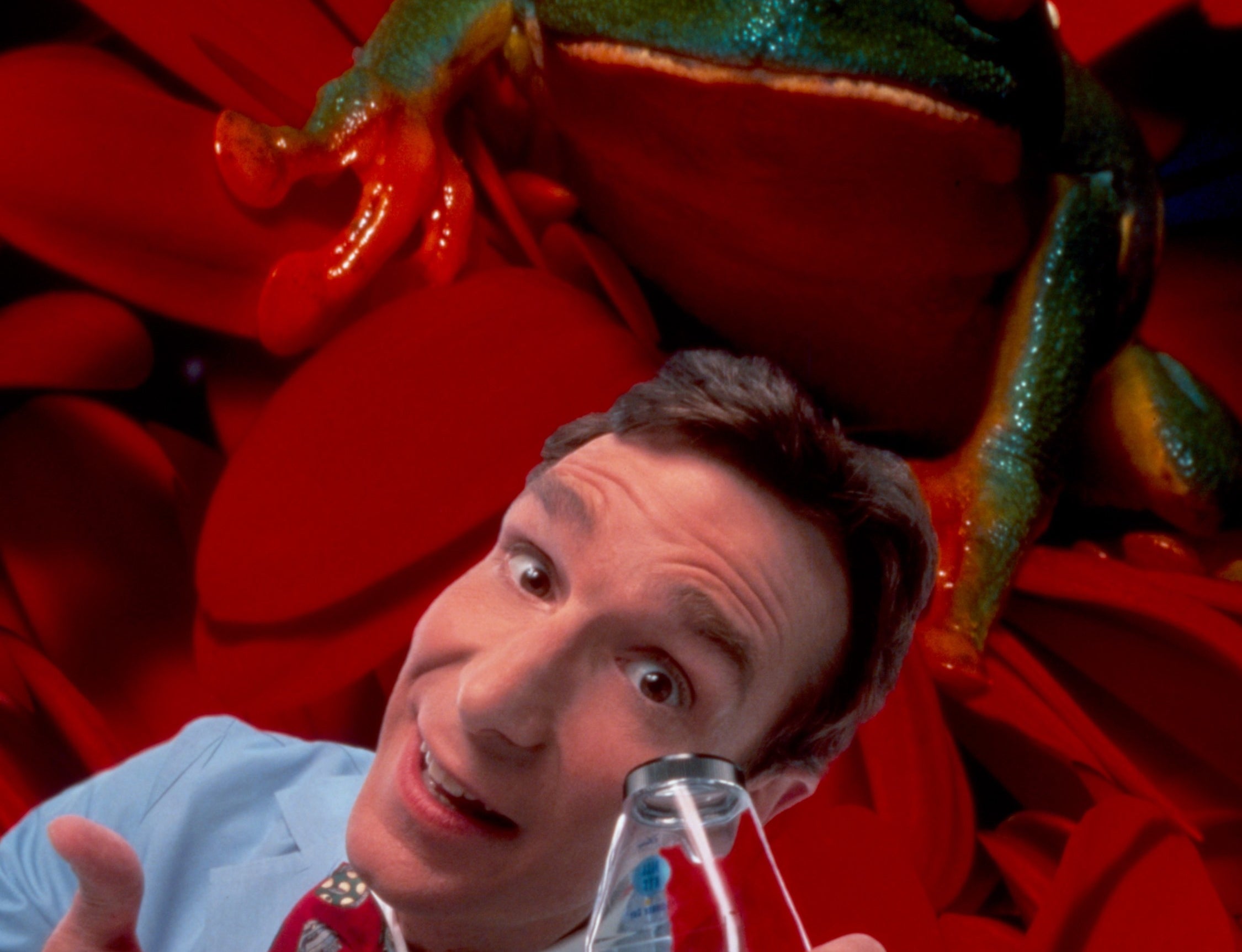 Bill Nye presents a science beaker to the camera
