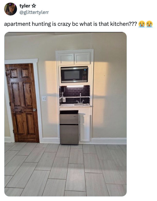 Dapur kecil dengan microwave, kompor, dan kulkas mini di ruang sempit. Tweetnya berbunyi: 