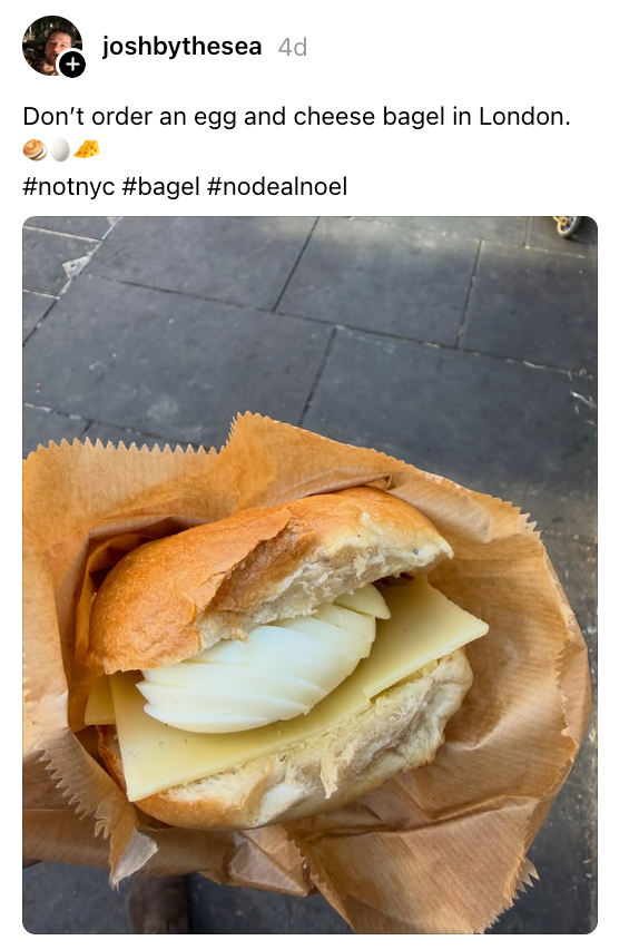 Bagel telur dan keju dalam kantong kertas coklat. Teks menyarankan untuk menghindari item ini di London