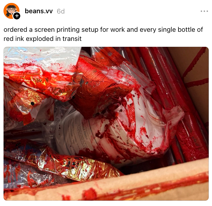 Kotak berisi peralatan sablon, dilapisi tinta merah bocor dari botol yang meledak