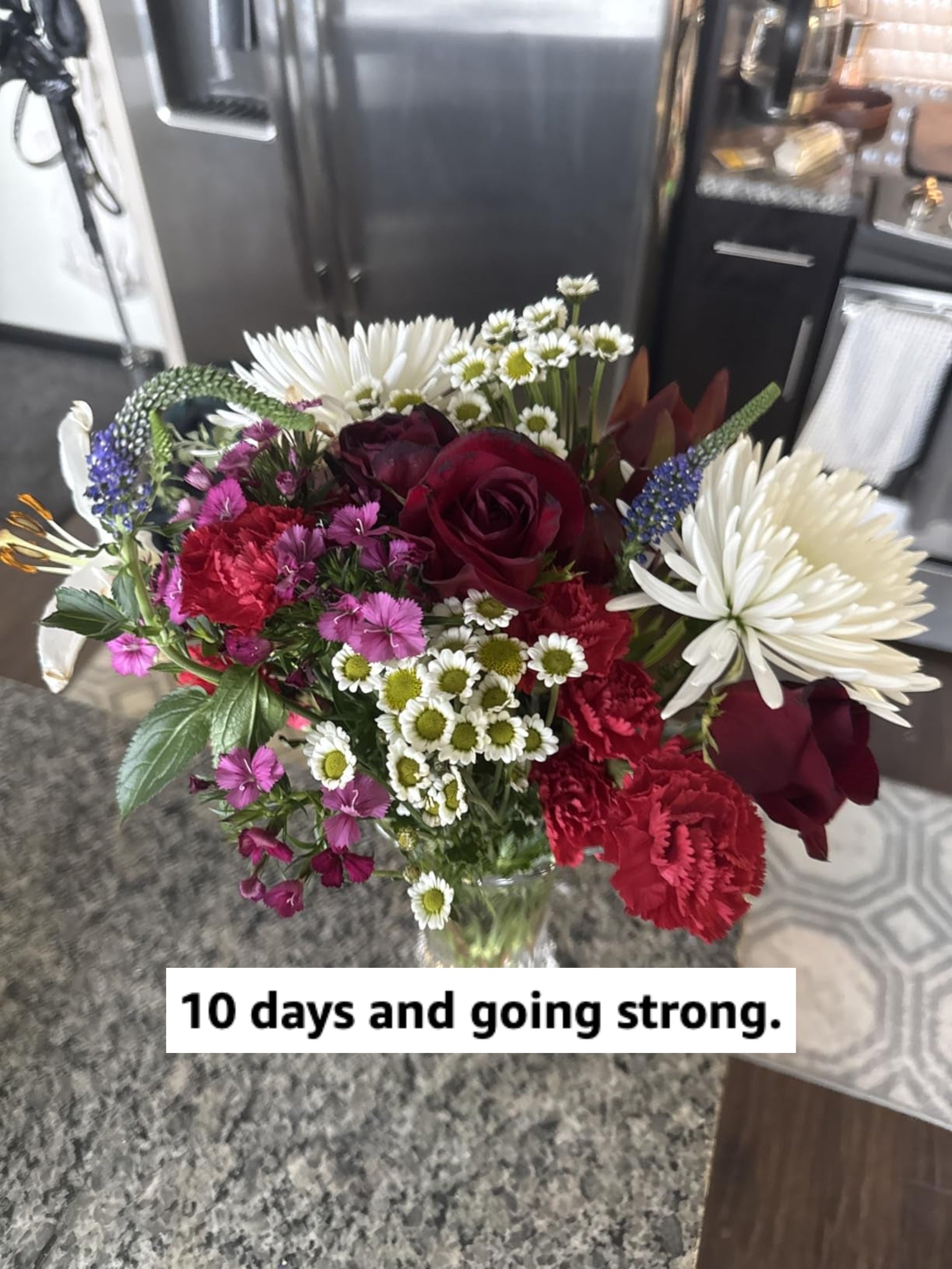 A vibrant bouquet of mixed flowers, including roses and daisies, arranged successful  a wide   vase connected  a room  counter. Ideal for gifting oregon  location  decor