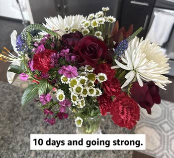 A vibrant bouquet of mixed flowers, including roses and daisies, arranged successful a wide vase connected a room counter. Ideal for gifting oregon location decor
