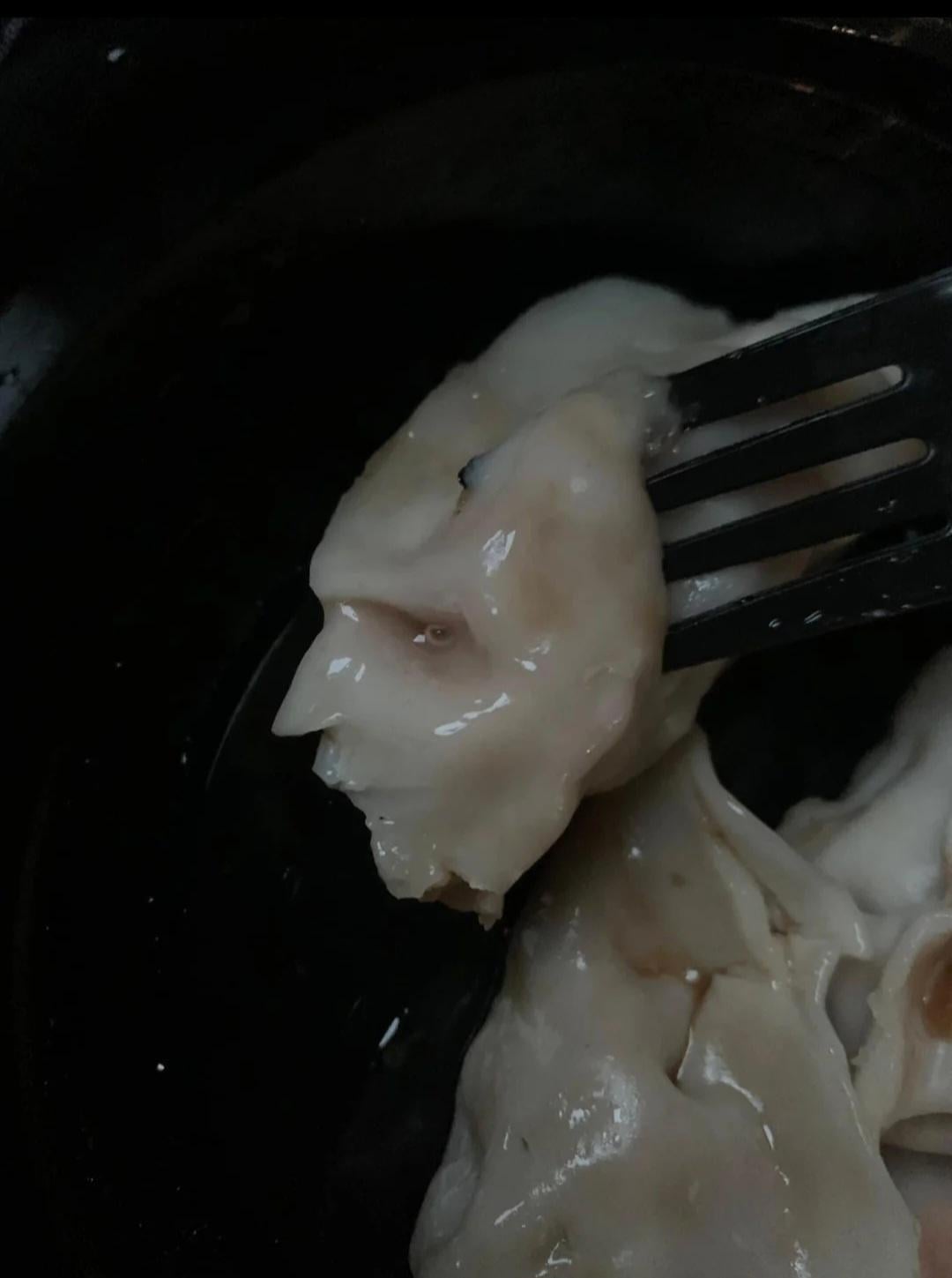 A fork holding dumplings, showcasing their translucent wrapper and soft texture