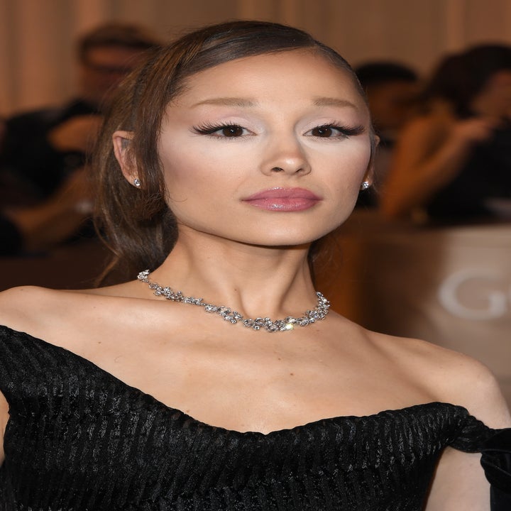 Person on the red carpet wearing an elegant off-the-shoulder dress with a diamond necklace