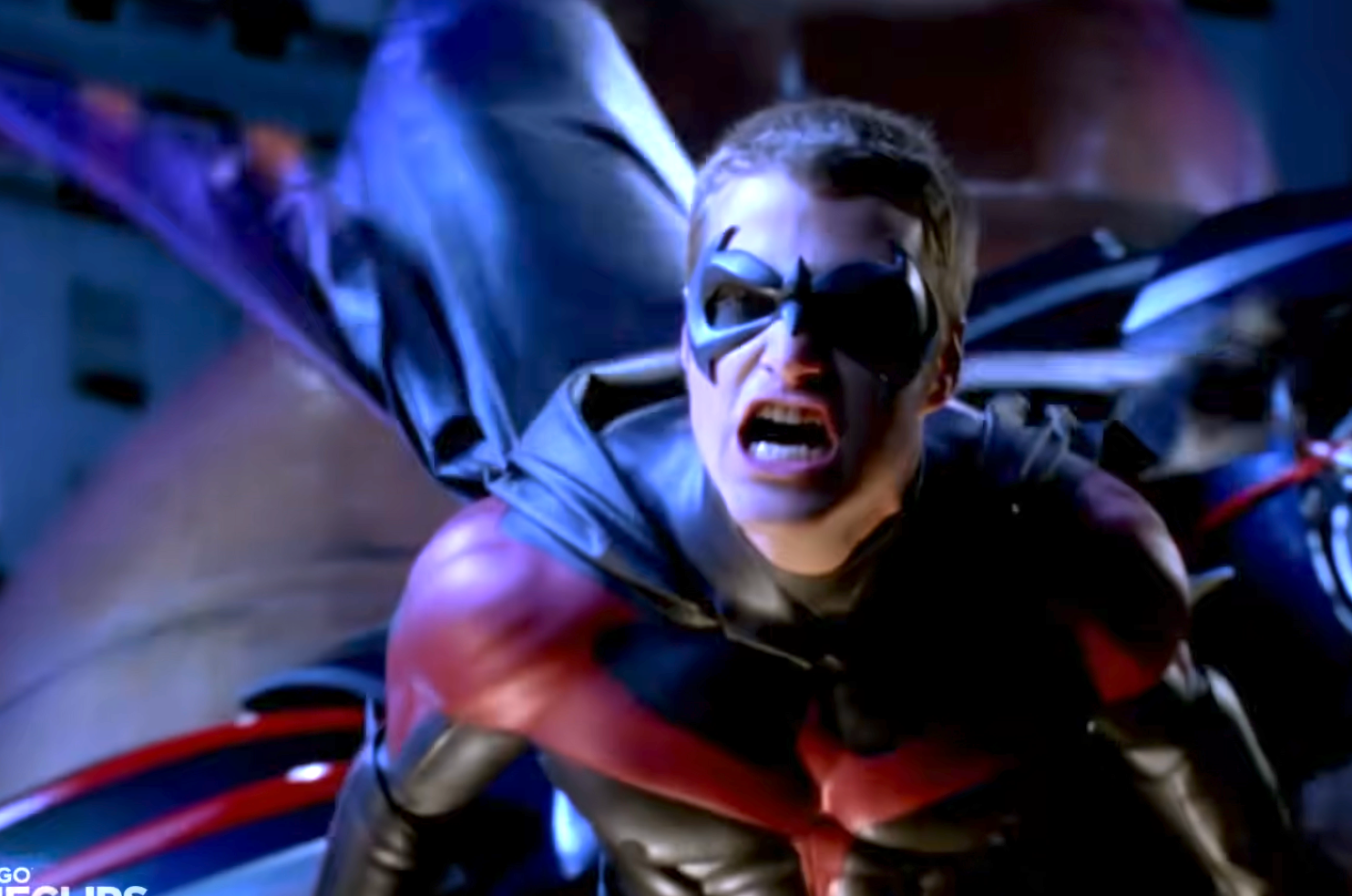 Chris O'Donell as Robin in a costume suit mid-action in a cityscape