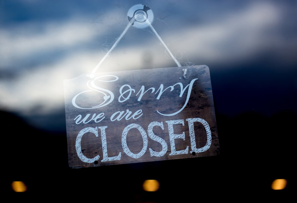 Sign on a door reads "Sorry, we are CLOSED." Reflected clouds and light hint at an outdoor setting, suggesting a business not open for visitors