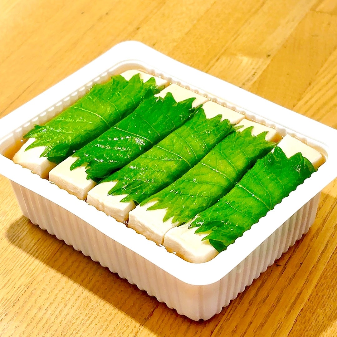豆腐のパックがテーブルに置かれている。