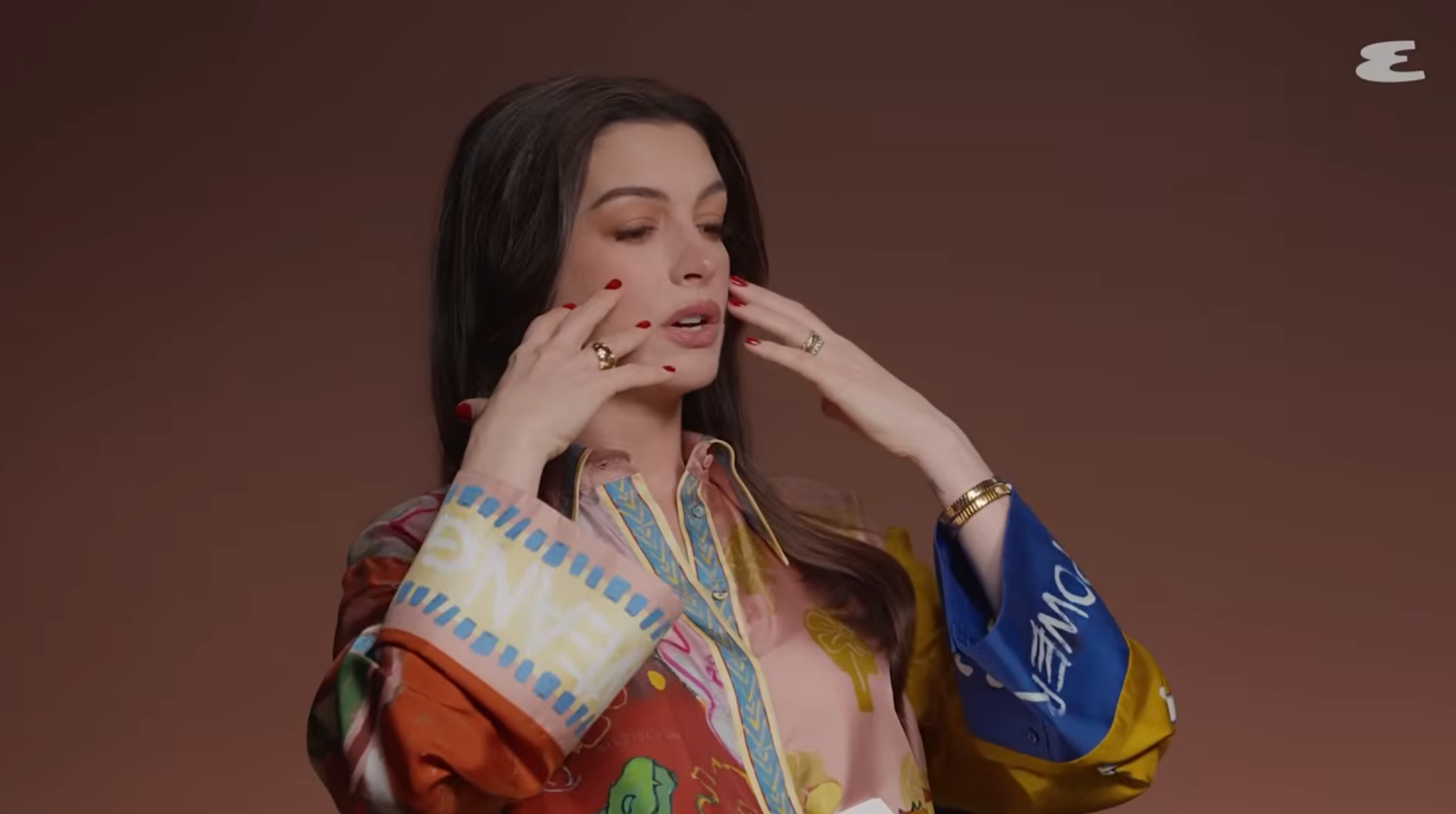 Anne gesturing with her hands near her face in an interview
