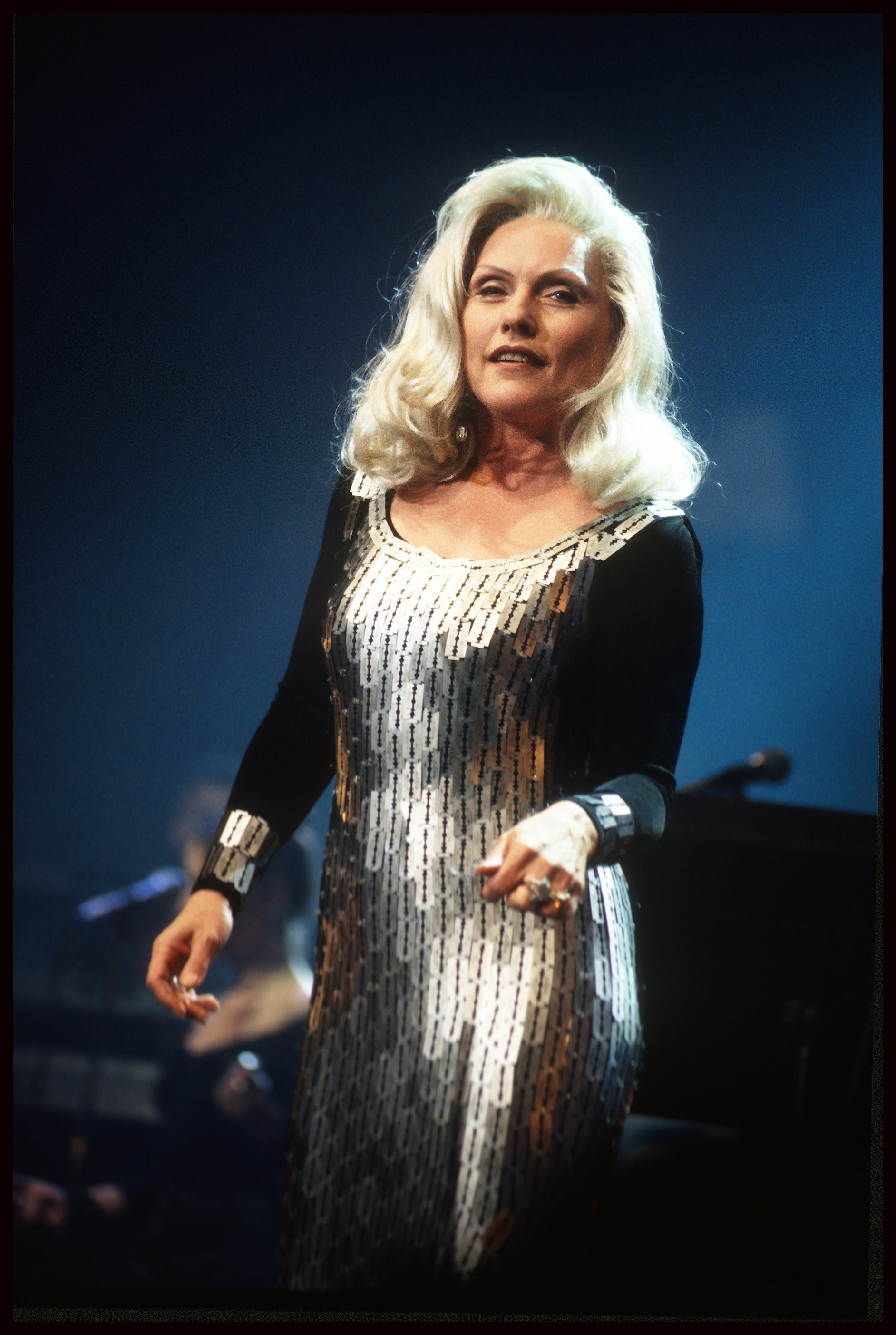 Person in a shimmering sleeveless dress performing onstage