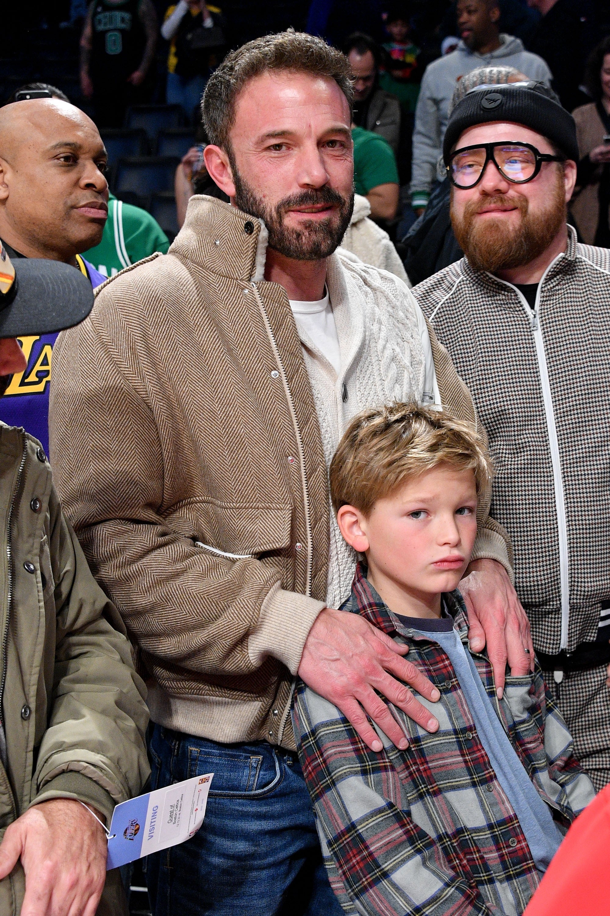 Person in a casual jacket posing with a child and two others at a public event