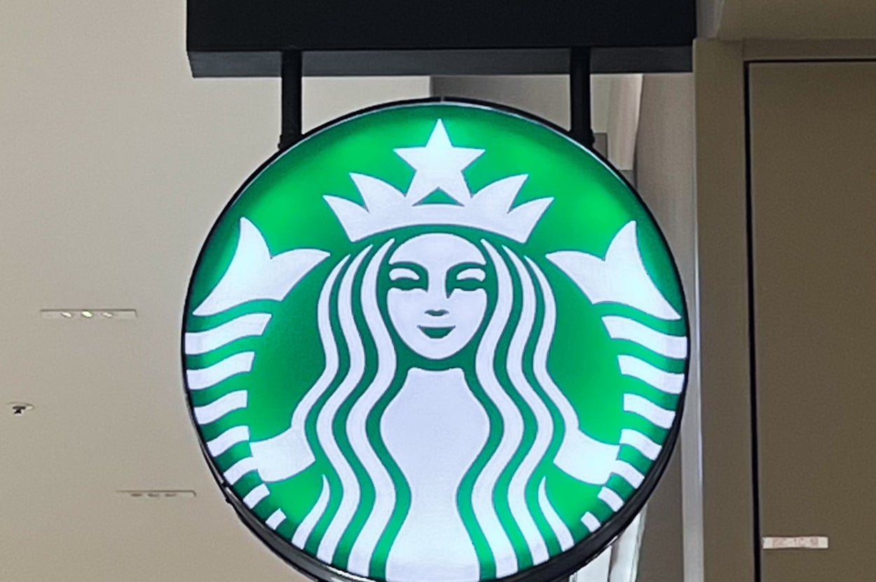 スターバックスのロゴが描かれた看板。店はショッピングモール内に位置しています。