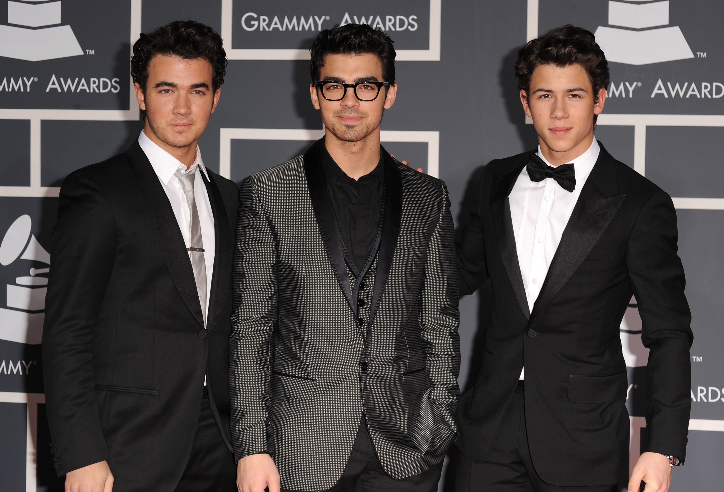Three men in suits at a Grammy Awards event