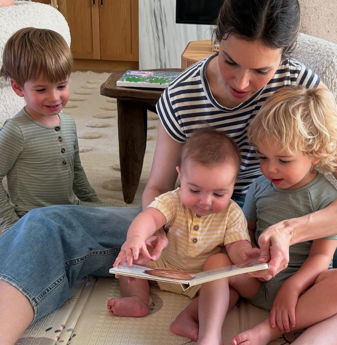 Mandy reading a book to three young children