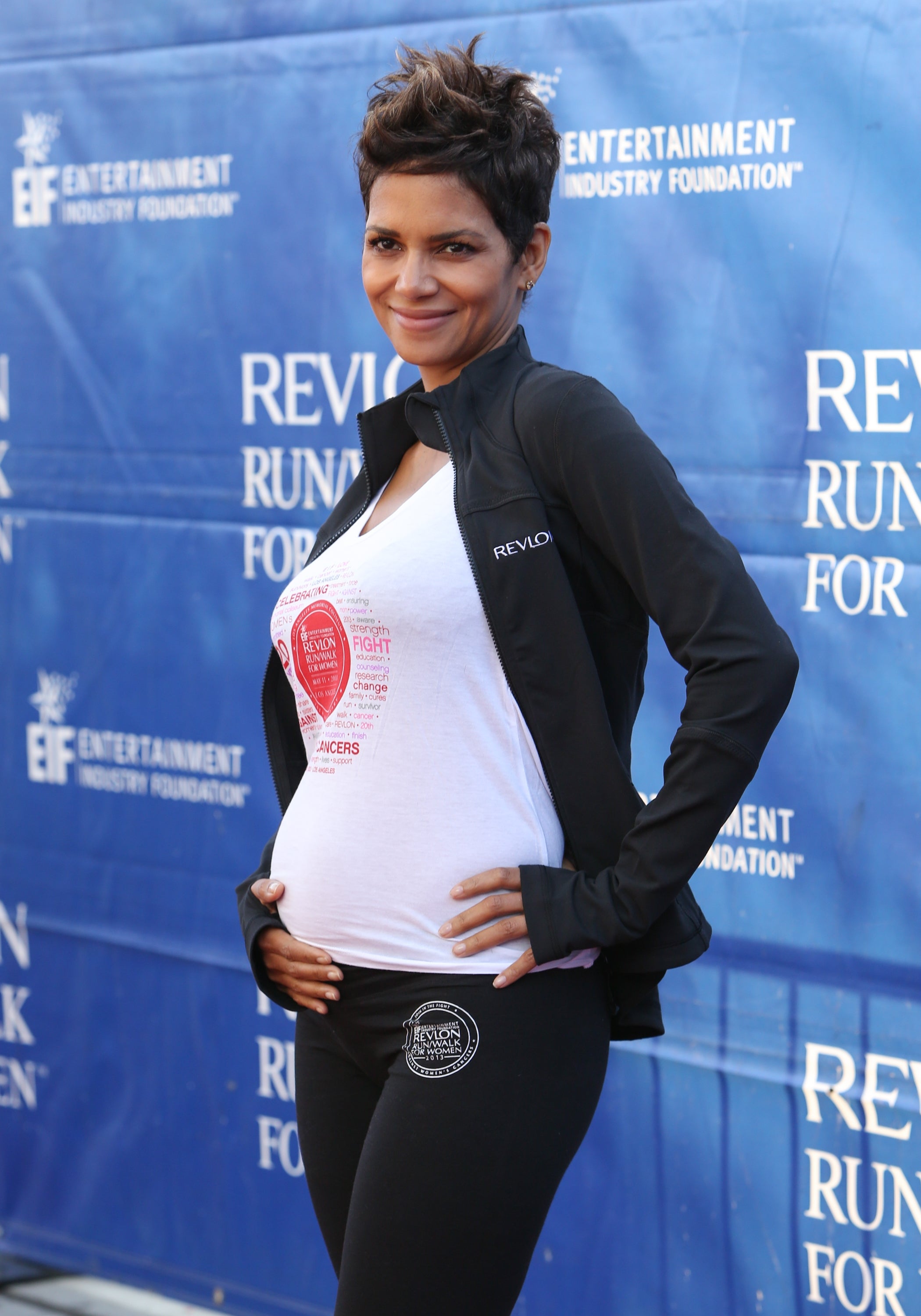 Halle at a charity event, holding her baby bump