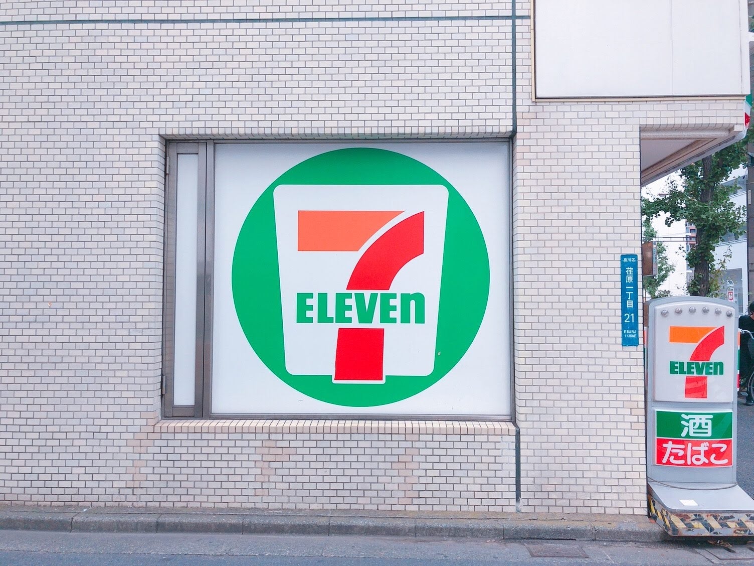 セブンイレブンの店舗外観。大きなロゴが壁に描かれている。