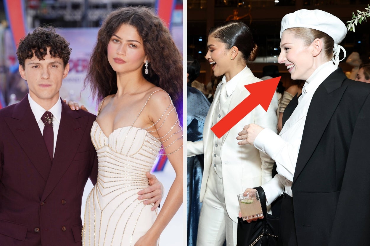 Two people on a red carpet; one in a burgundy suit, the other in an elegant strapless dress with bead details