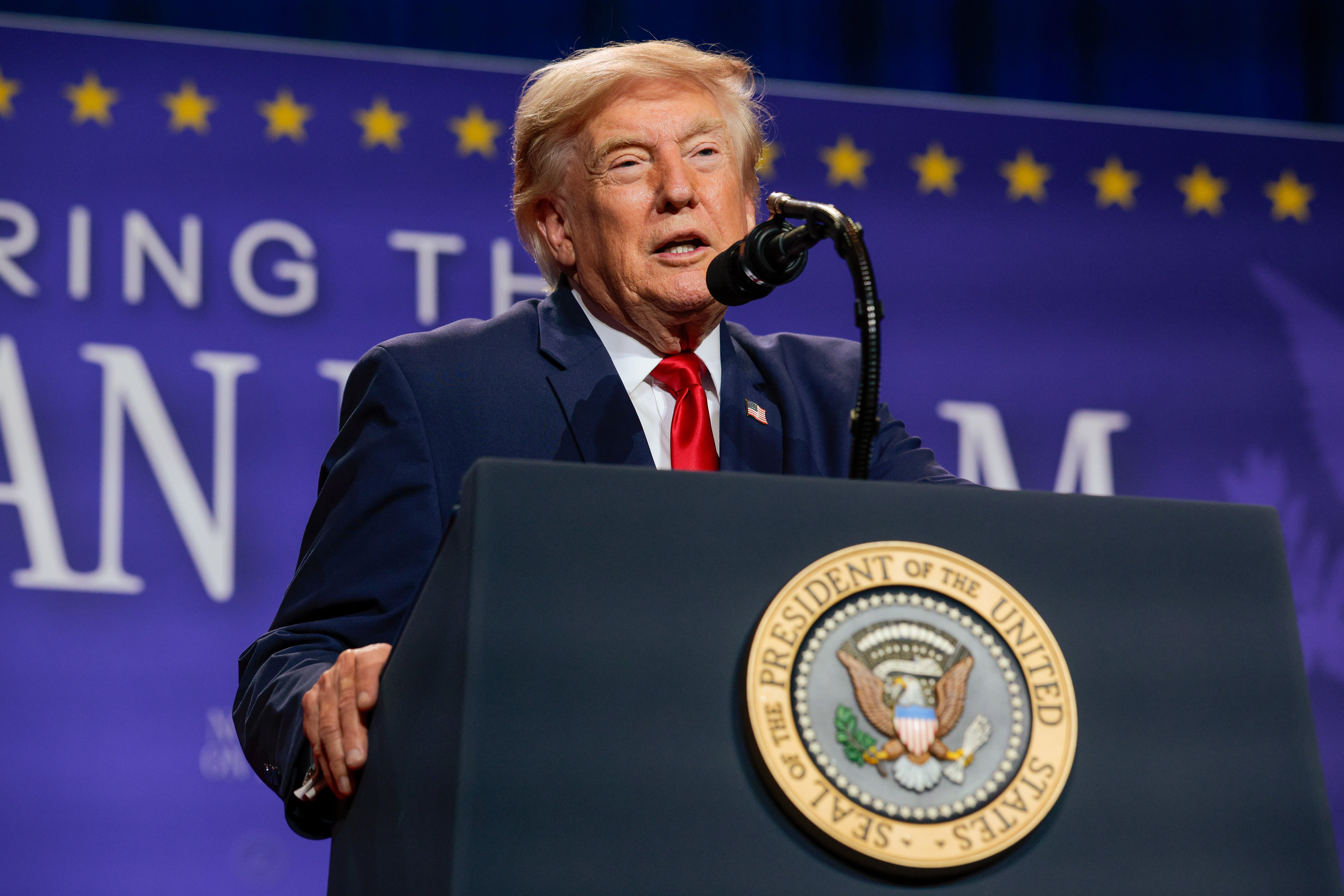 En person som taler ved et podium med seglet til presidenten i USA, og holder en tale ved et arrangement